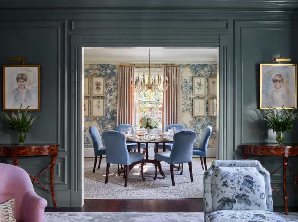 Elegant dining room with blue upholstered chairs, floral decor, and classic chandelier, showcasing s.
