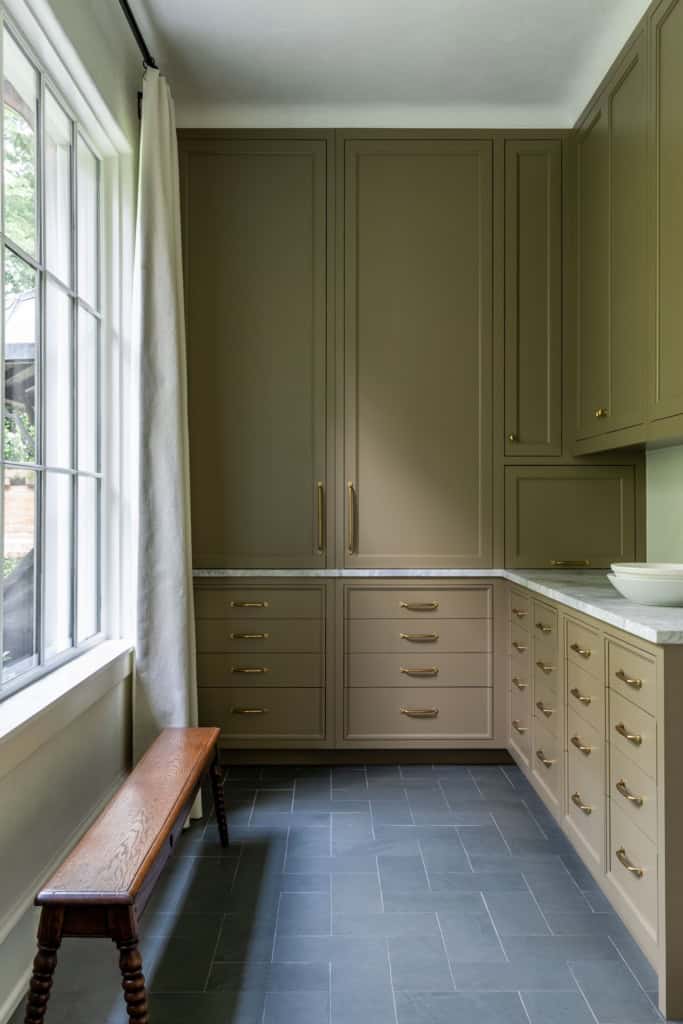 Modern kitchen with beige cabinets and natural light from large window.
